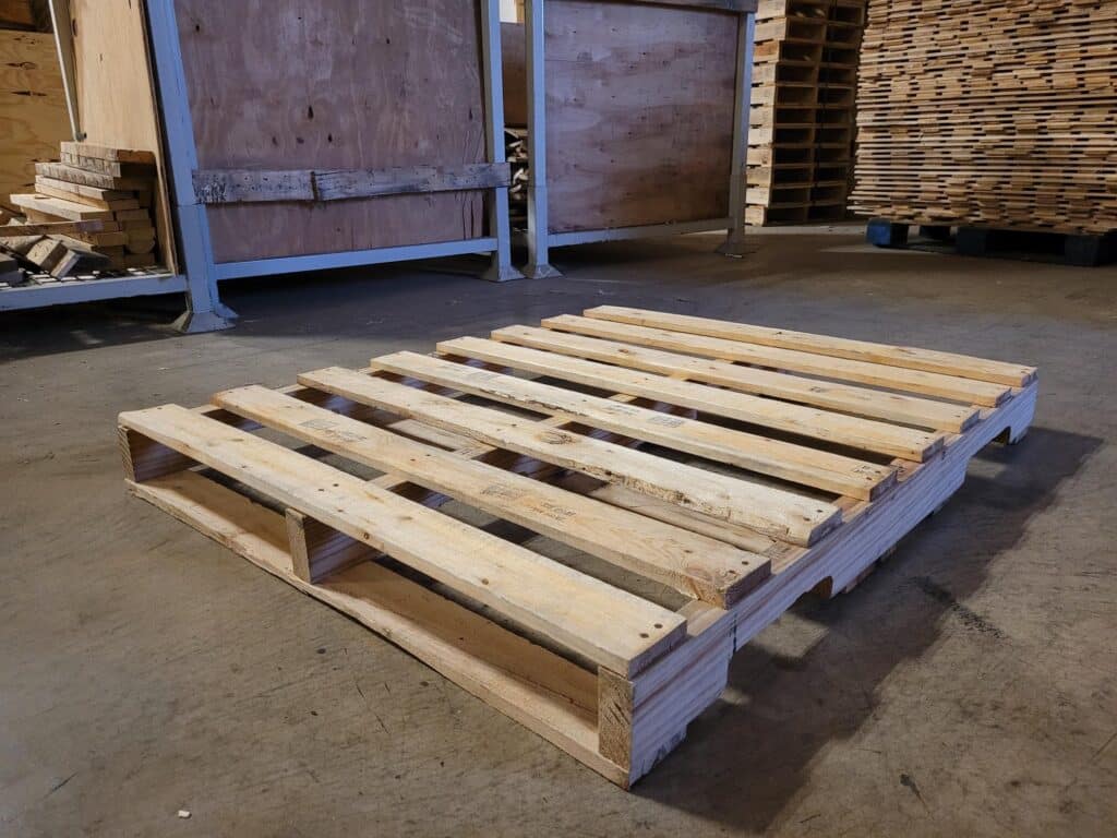 High-quality Grade A recycled wooden pallet with clean deck boards and un-repaired stringers in a Milwaukee warehouse.